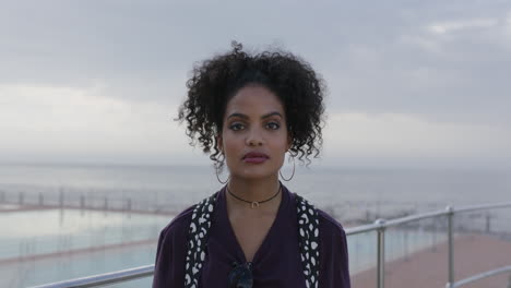 portrait of beautiful hispanic woman looking confident proud by ocean seaside close up of gritty independent woman