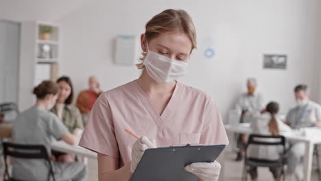 caucasian nurse writing and posing