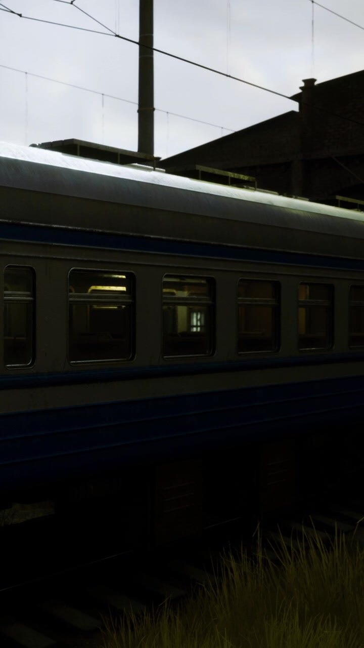 Train parked near a building during evening hours with low light