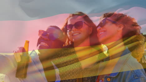 Composite-video-of-waving-germany-flag-over-diverse-girls-taking-a-selfie-outdoors-near-a-car