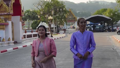 two women in traditional thai clothing at a temple