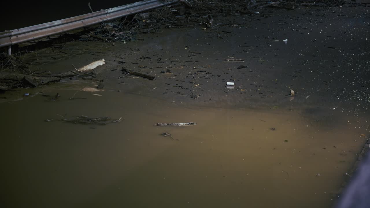 Flood Debris and Pollution in Urban River at Night
