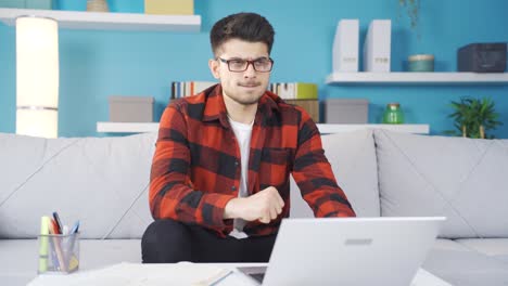 joven trabajando en una computadora portátil resentido por el fracaso.