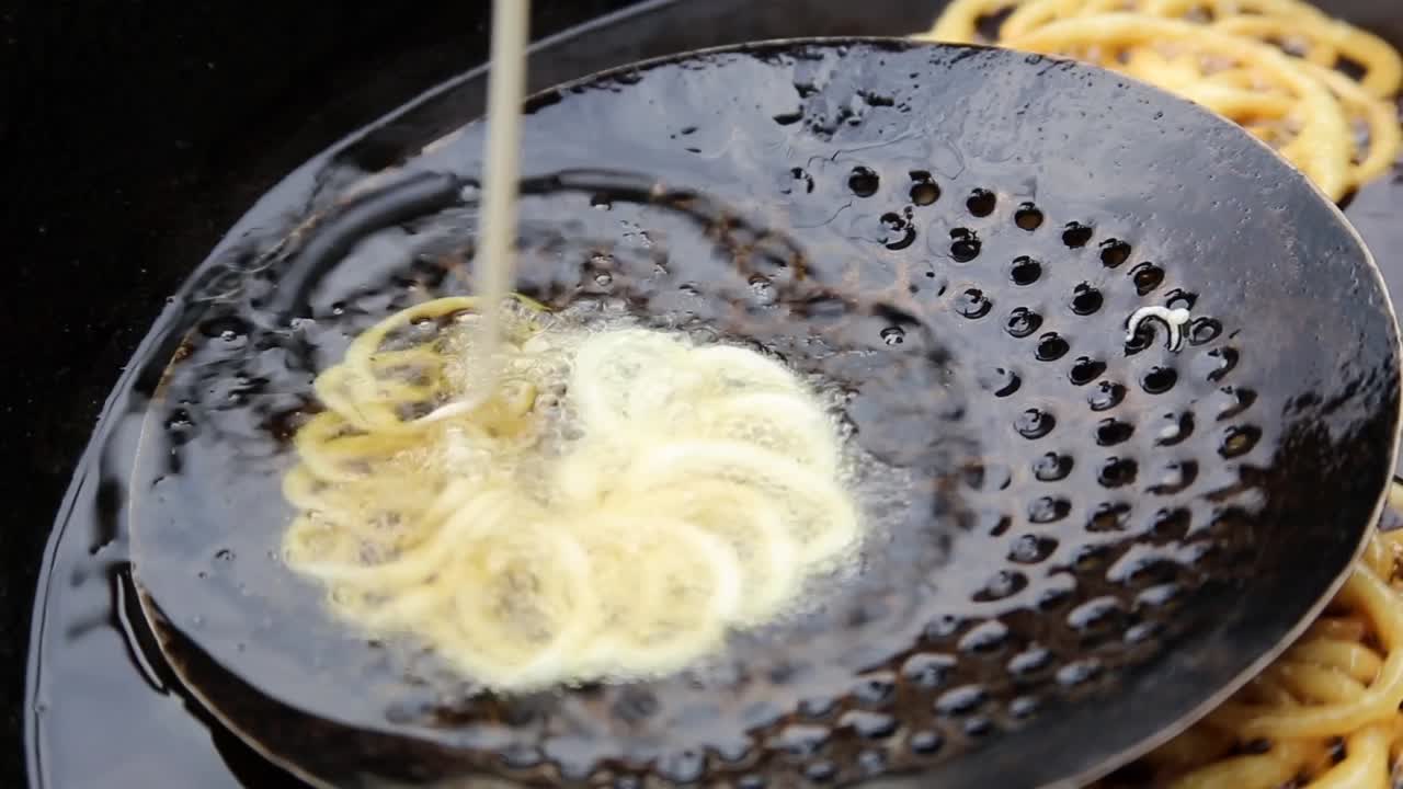 primer plano de jollibee dulce-jalebi siendo frito en jarabe