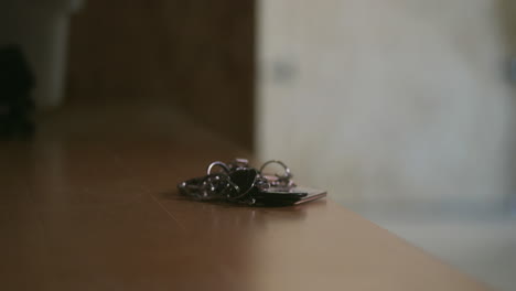 silhouette of person putting keys on table and walk away