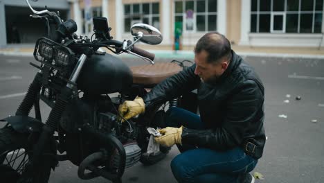 man repairing a vintage motorcycle