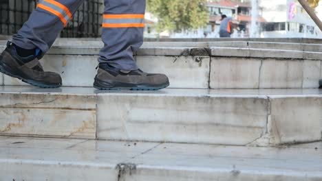 a man walking up a set of stairs while cleaning the street