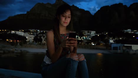 Woman-using-mobile-phone-on-promenade-at-beach-4k