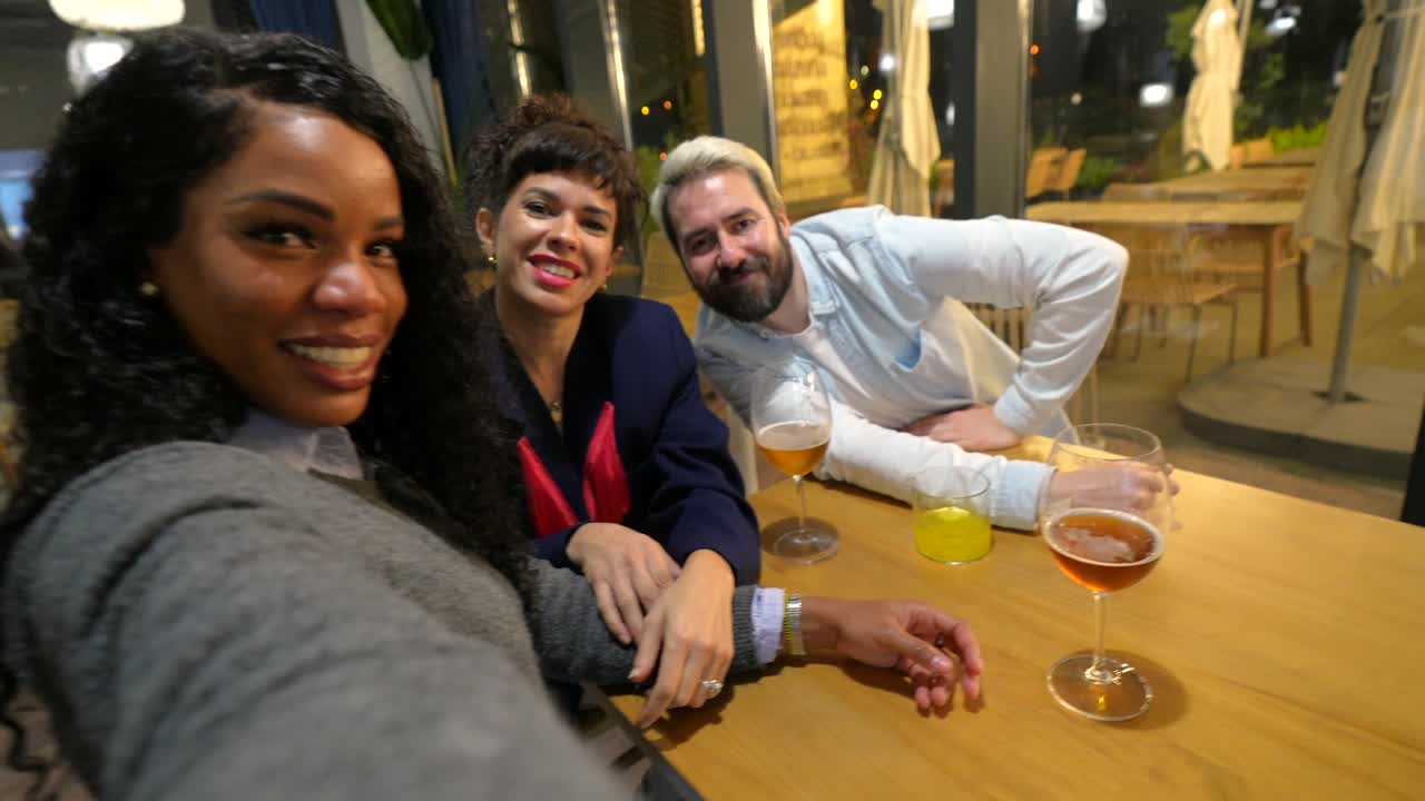 Grupo de amigos tirando selfies em um restaurante