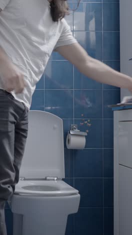 person disposing of paper into a toilet in a bathroom