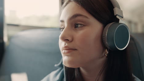 closeup thoughtful girl face with headphones. portrait teenager listening music.
