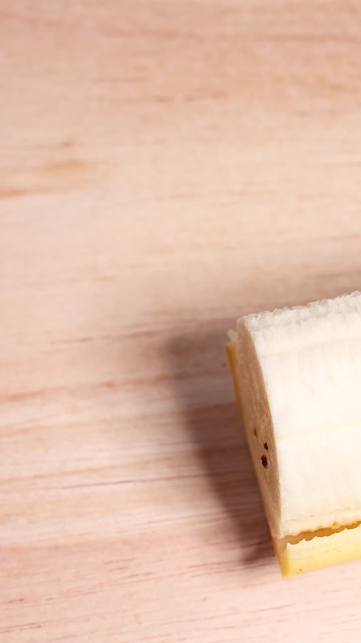 A hand peels a banana on a table