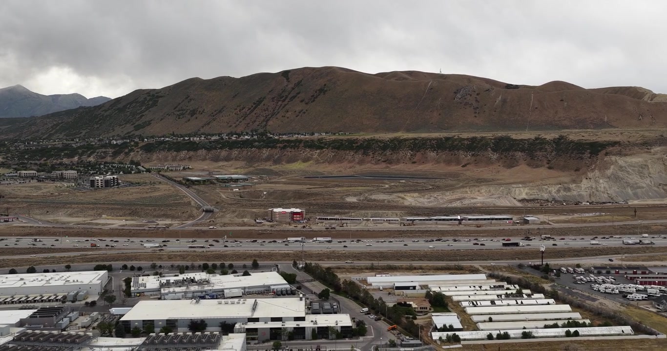 Centro de dados Granite Point Campus estende-se sob as Montanhas Traverse em Draper, Utah, ao lado da rodovia I-15, hyperlapse deslizante de drone