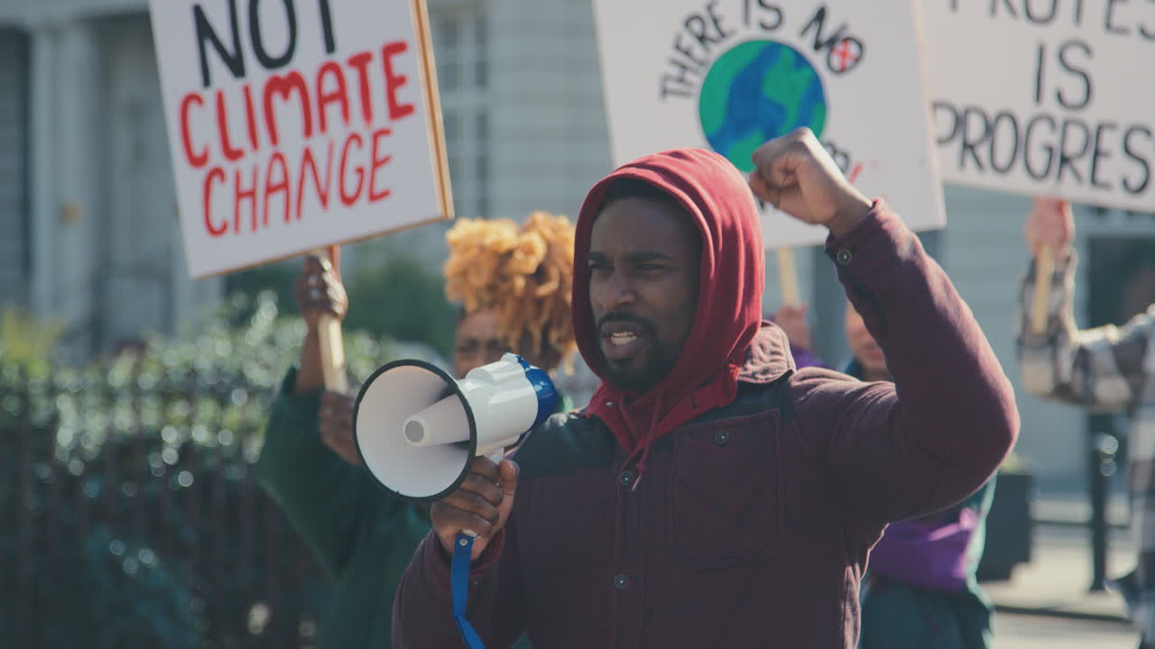 grupo de manifestantes con pancartas y megáfono en una marcha de manifestación contra el cambio climático