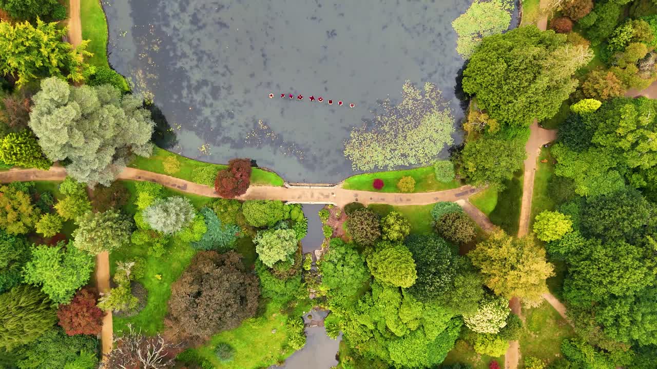impresionante vídeo aéreo de jardines cuidados y lagos tranquilos, rodeados de parques históricos y bosques verdes