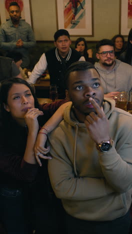friends watching a sporting event in a pub