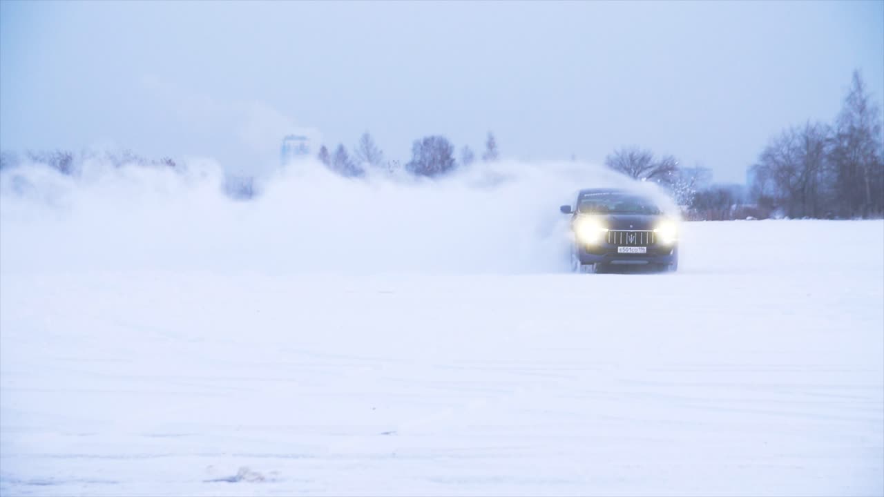 어두운 파란 suv가 눈 에 운전하고 있습니다.