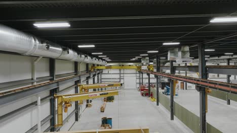 push-in-drone-shot-of-a-large-commercial-warehouse-with-heavy-lift-machinery