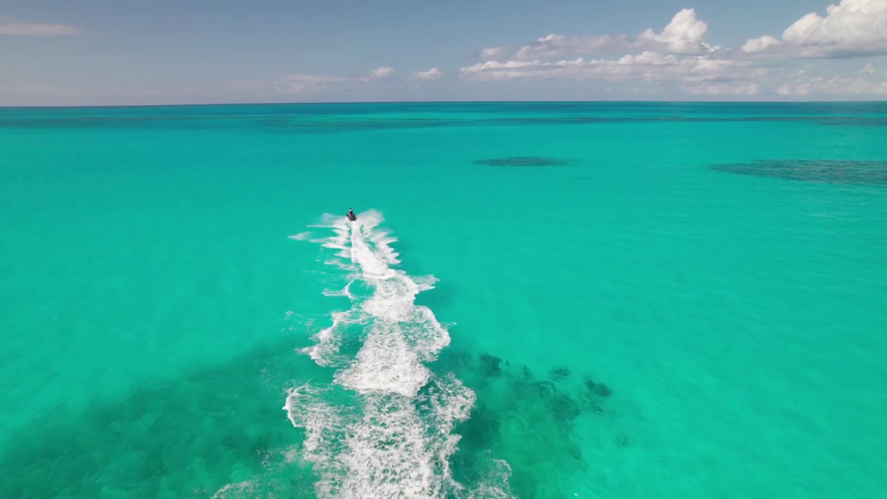 Moto d'acqua in splendide acque caraibiche, ripresa aerea 4K dall'alto con drone