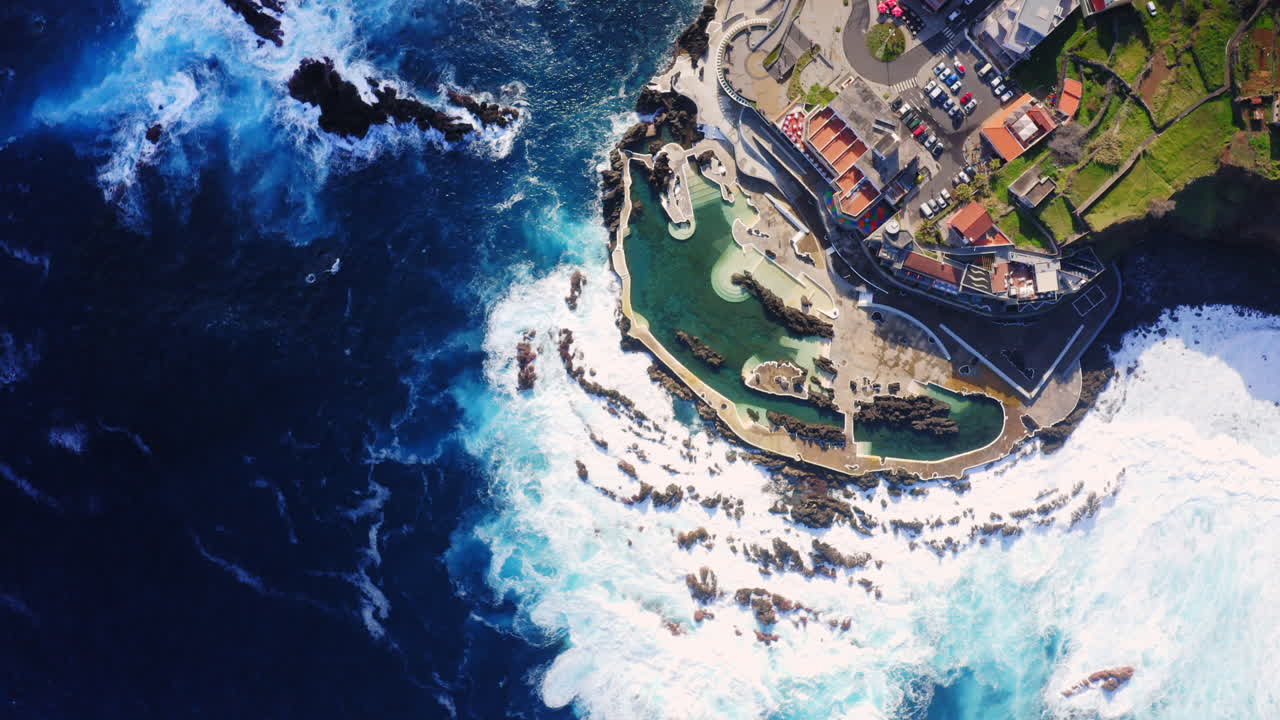 흰 거품이 있는 바위에 부딪히는 파도의 높은 각도 하향식