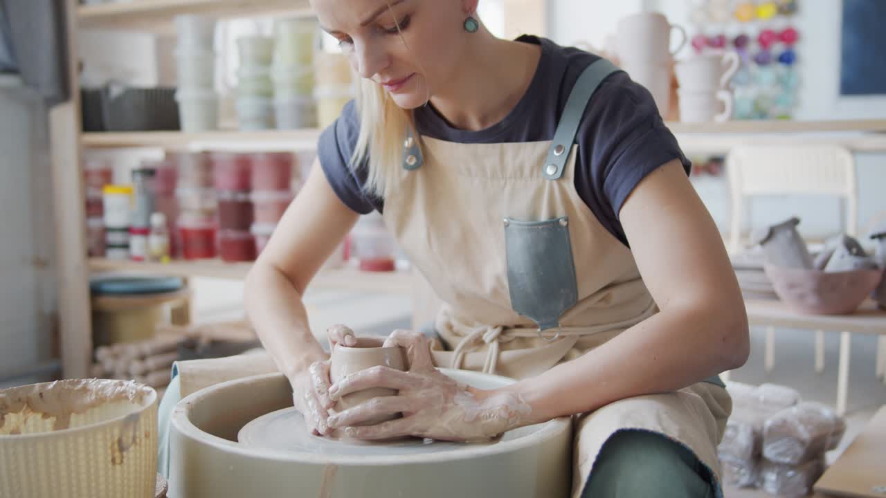 여성 도자기는 도자기 바에 도자기를 만니다.