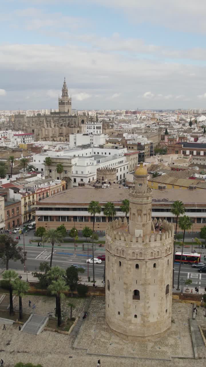Volo che si allontana dalla storica Torre del Oro, rivelando la Cattedrale di Siviglia sullo sfondo. Ripresa Aerea Verticale.