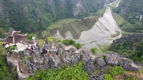 aerial 360 overhead view of tourists walking along hang mua to viewpoint summit