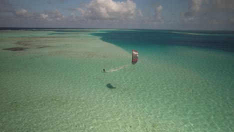 Kitesurfer-Gleitet-An-Einem-Sonnigen-Tag-über-Klares,-Türkisfarbenes-Wasser