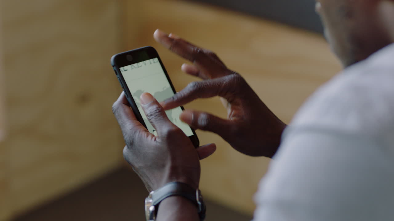 close up uomo d'affari afroamericano che usa smartphone navigazione dati di ricerca online lettura informazioni sul mercato progetto studente visualizzazione di startup società di sviluppo statistiche sullo schermo del telefono cellulare