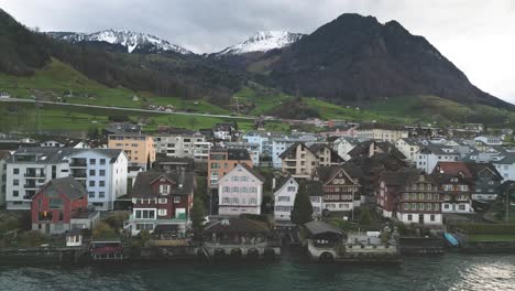 Aerial-View-of-Idyllic-Beckenried-Village-on-Coast-of-Lake-Lucerne,-Switzerland,-Residential-Buildings-Under-Swiss-Alps