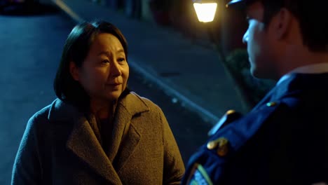 woman talking to police officer at night