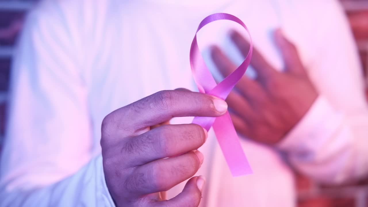 Persona che tiene un nastro rosa per la sensibilizzazione sul cancro