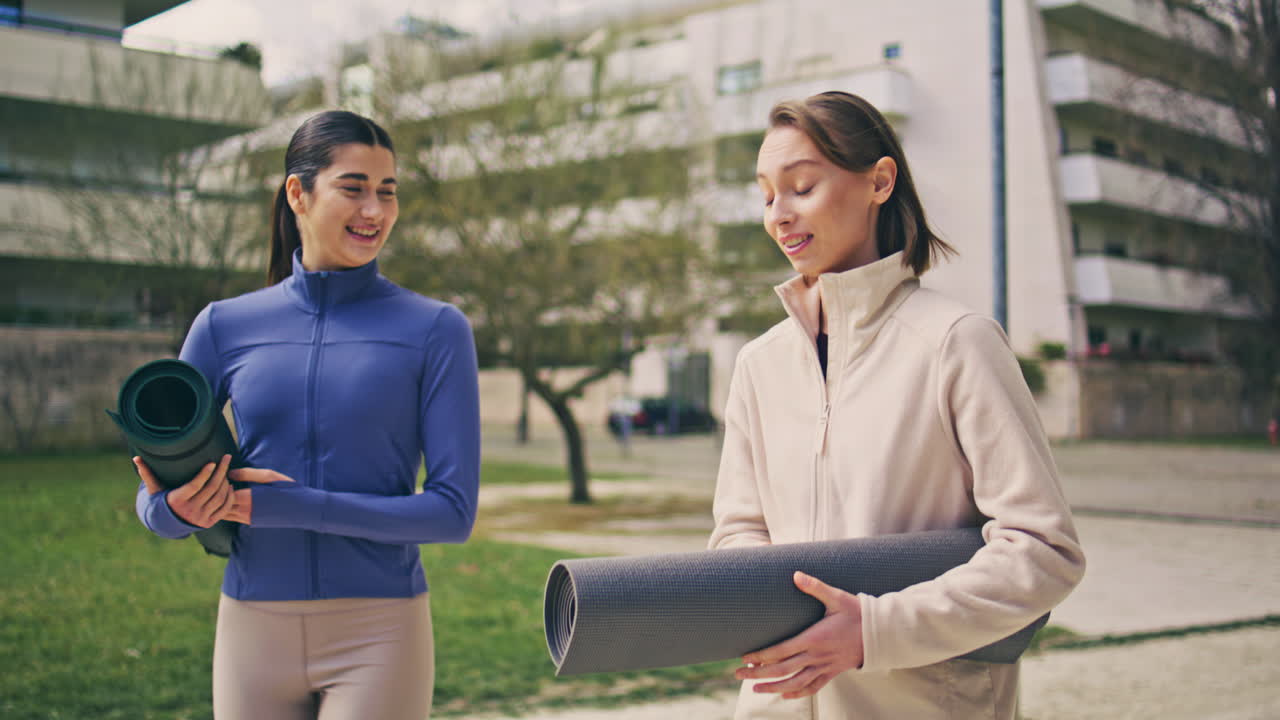 Yogi women walking street to fitness training. Happy ladies talking together