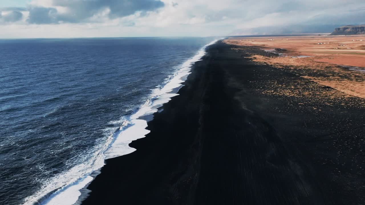 vista en ángulo alto de la playa de arena negra en islandia durante un día soleado y caluroso en verano