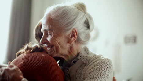 joyful elderly woman embracing granddaughter with affection and smiling happily