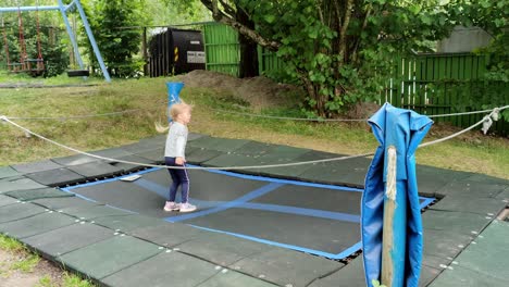 Young-girl-jumping-at-trampoline-in-Norway-playground---All-alone-at-playground-having-fun--Handheld-static-at-playground-Norway
