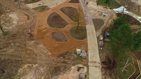 tilting drone images of a park under construction, a bulldozer at work