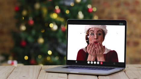 feliz mujer caucásica en disfraz de santa en videollamada en computadora portátil, con decoraciones de navidad y árbol