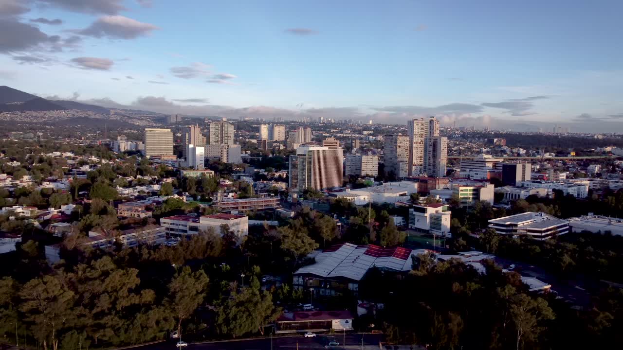 toma aérea de las afueras del sur de la ciudad de méxico cerca de la ciudad universitaria al amanecer que muestra varios edificios de varios tipos, viviendas, oficinas y centros comerciales