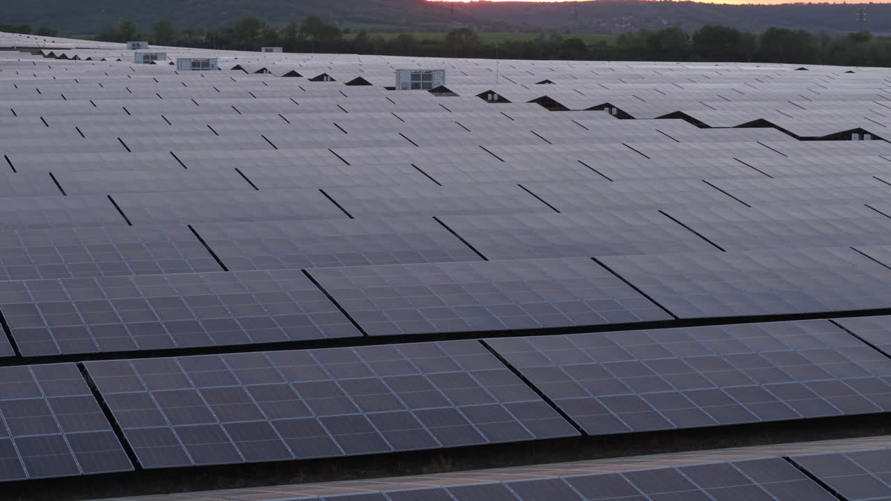 A beautiful drone view of solar panels glowing under the evening sun. Located in a scenic Bulgarian field, the solar array represents the shift toward renewable energy and sustainable technology.