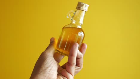 Hält-Eine-Flasche-Olivenöl-In-Der-Hand