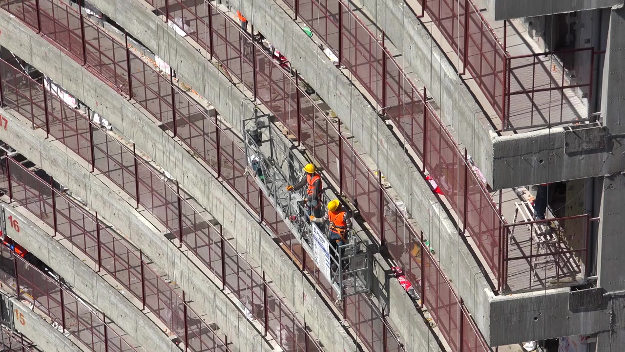 Construction Workers on Suspended Scaffolding at High-Rise Building