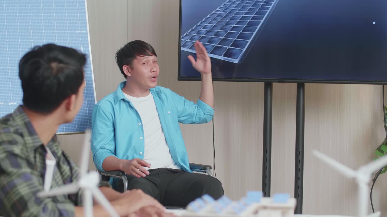 체어에 앉은 아시아인 엔지니어가 사무실에서 태양전지 작업에 대해 성공적으로 발표하면서 관객들은 박수를 치며 인상적 느낌을 받았습니다.