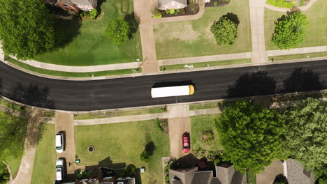 overhead view of school bus driving in the asphalt road