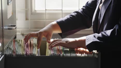 female staff searching for documents in the office filing cabinet