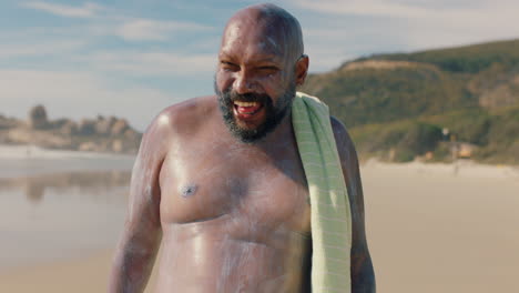 hombre gracioso con sobrepeso en la playa cubierto de loción solar sintiéndose confiado disfrutando del día de verano con protector solar en el cuerpo 4k