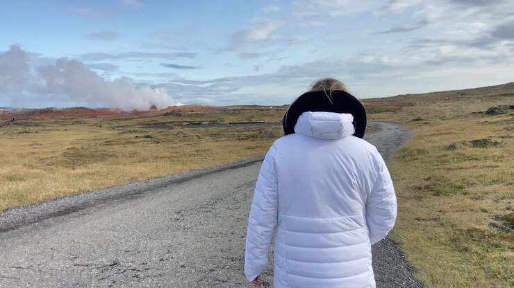 Photographer female tourist visiting Gunnuhver geothermal area in Iceland