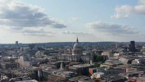 Slide-and-pan-aerial-view-of-Saint-Pauls-Cathedral-in-city-centre.-Multistorey-buildings-around.-London,-UK