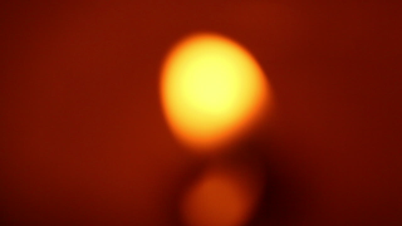 animación basada en una llama de vela redonda y borrosa sobre un fondo rojo y negro oscuro