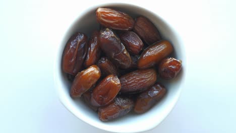 hand reaching into a bowl of dates